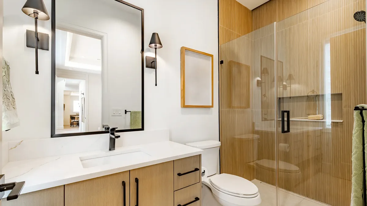 Finished bathroom with a wood-tile glass shower, floating vanity and quartz counter